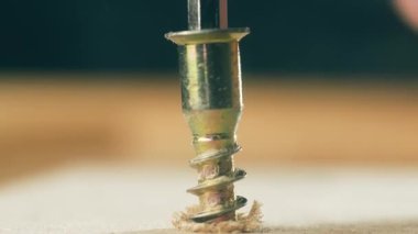 Kapalı sarı kendine dokunmalı vida sıkma adam tarafından ahşap allen anahtarı kullanarak daralıyor. Macro view inşaat sabitleyicisi tamirci tarafından ingiliz anahtarıyla yüzeye dönüyor. Pirinç donanım elle çalıştırıcı uygulayarak malzeme içine çalışan