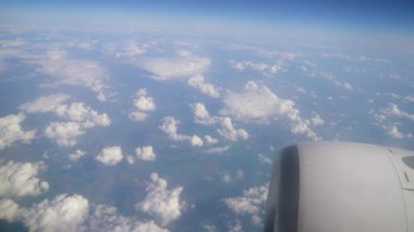 Pofuduk Bulutlar ve Mavi Gökyüzü Uçuşun Gündüz Uçuşu sırasında Geniş Manzaralar Üzerinde. Uçsuz bucaksız mavi gökyüzüne yayılmış yumuşak beyaz bulutlar.