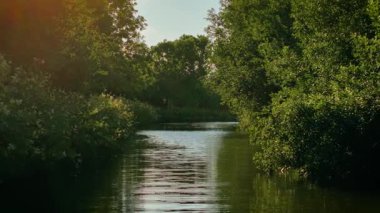 Dar kayık İngiliz kanalı boyunca süzülüyor. Filika, yeşil koridorda tekne açısından usulca ilerliyor. Yoğun ağaçlar ve yumuşak dalgalarla çevrili bir su yolu. Geleneksel kanal yolunda huzurlu bir yaz tatili