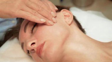 Terapist, rahatlamak için şakak bölgesine nazikçe masaj yapıyor. Uzman, baş tarafına hafif basınç uyguluyor. Sakinliği ve dengeyi arttırıyor. Uygulayıcı, dinginliği ve gençliği destekleyen hassas hareketlerle tapınak bölgesini yatıştırıyor.