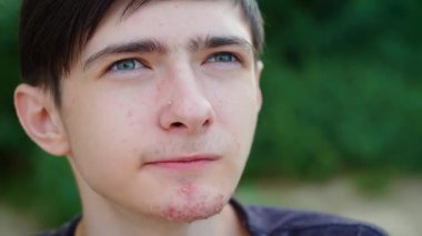 Elma dilimi yiyen genç bir çocuk. Düşünceli bir ifadeyle gevrek ve sulu lezzetin tadını çıkarıyor. Erkek ısıran elma dilimi, taze ve tatlı tatların tadını çıkarıyor. Elma dilimini seven adam, ferahlatıcı ve doğal ısırığa daldırılmış.