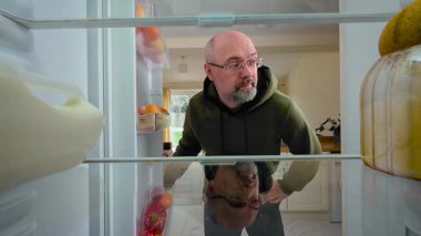 Adam sürekli buzdolabını açıyor ve umut dolu bir ifadeyle buzdolabının içini seyrediyor. Erkek, sihirli bir şekilde yemeğin ortaya çıkmasını bekliyor ve sabırsızlanıyor. Meraklı ve hayal kırıklığına uğramış bir adam boş buzdolabına bakıyor.