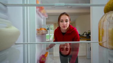 Kadın sürekli boş buzdolabını açıyor, bir şeylerin ortaya çıkmasını umuyor, buzdolabının içini görüyor. Genç bayan hayal kırıklığına uğramış ve düşünceli görünüyor. Rafları küçük bir hayal kırıklığı ve beklentiyle kontrol eden bir bayan.