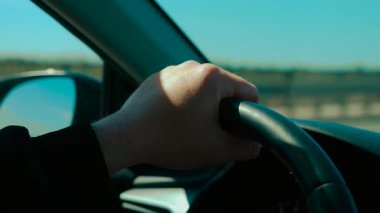 Tanımlanamayan bir adam açık havada araba kullanırken direksiyona el basmak. Erkek seyir yolu, güçlü bir odak ile sürükleyici tekerlek. Sürücü kontrolü, güneşli yol boyunca seyir aracı
