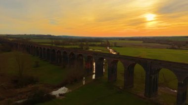 Güneş ufkun altına batarken viyadük. Güneşin batışı güzel vadinin üzerinde, önünde tren viyaoluğu var. Ünlü tarihi yerler, çarpıcı doğada ulaşım yolları.