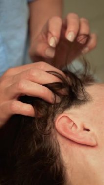 Terapist stres atmak, gençleşmek ve dikey yönelim için kafa masajı yapıyor. Kan dolaşımını arttırmak ve gevşemeyi teşvik etmek için saç köklerini nazikçe uyaran yetenekli bir uzman. Profesyonel, serbest bırakmak için dikkatli teknikler kullanıyor.