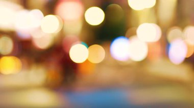 Bulanık bisikletçi hareket halindeki arabalarla şehir caddesinden geçiyor. Odaklanamayan bisiklet sürücüsü parlayan şehir yolunda gidiyor. Renkli gece ışıklarıyla trafiğin yanında seyahat eden odaksız motorcu