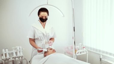 Kozmetik uzmanı cilt bakımı kliniğinde cilt temizleyicisi kullanıyor. Kadın uzmanımız nazik deri yüzme ve derin gözenek temizleme üzerinde çalışıyor. Bayan güzellik uzmanı, yenilenmiş ve parlayan cilde profesyonel bakım sağlıyor.