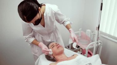 Gelişmiş estetik atölyesinde cilt bakımına odaklanan kişisel stilist. Uzman, cilt berraklığını ve tonunu arttıran profesyonel tedavi sağlıyor. Terapistin müşteriye dikkatle hitap etmesi gençleşmeyi ve rahatlamayı teşvik eder.