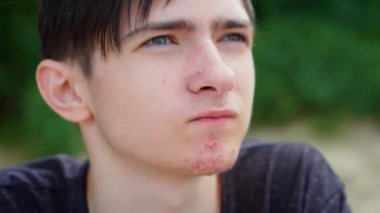 Erkek çocuk kırmızı çilek yiyor, tatlı ve keskin tadını çıkartıyor ve odaklanmış ifade ediyor. Erkek ısıran kırmızı çilek, sulu ve taze lezzetin tadını çıkarıyor. Kırmızı çilekten hoşlanan adam, doğal ve lezzetli duygulara dalmış.