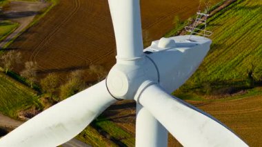 Rüzgar çiftliği yeşil enerji üretiyor. Rüzgar türbini yeşil güç yaratmak için dairesel bıçaklar çeviriyor. Rüzgâr çiftliğinde rüzgar enerjisi üreten büyük bıçaklar yapmak.