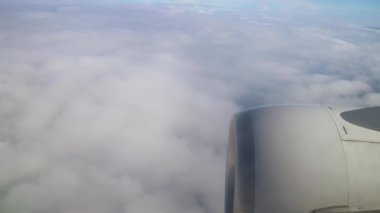 Tranquil Flight Upbove Horizon sırasında Parlak Gün Işığında Pofuduk Bulutların Uçak Penceresinden görünüşü. Uçaktan bulutlu görüntü ve kanatta jet