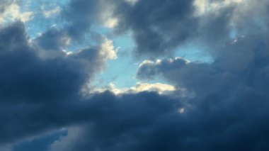 Gökyüzünün üzerinde dönen fırtınalı bulutlar. Karanlık kümülüs kütleleri kasvetli gökyüzünde kayıyor. Yoğun hava bulutları dramatik gökyüzü deseninde toplanıyor