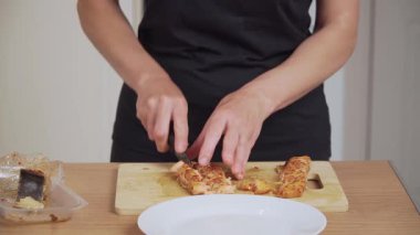 Gemide füme balığı parçalara ayırmak. Baharatlı filetoyu bıçakla dilimleyen tanınmamış biri. Pişirmek için tütsülenmiş somon parçaları hazırlıyorum. Tütsülenmiş balık parçalarını suşi ruloları için hazırlıyorum.