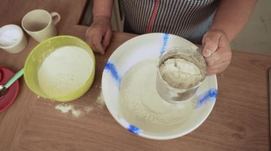 Unu kase içine süzmek. Tanınmayan kişi barutu tencereye koyuyor. İçindekileri konteynıra dolduruyorum. Ev yapımı ekmek için hamur hazırlıyorum.