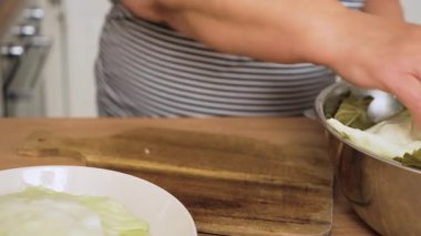 Lahana yaprağının kalın bir kısmını dilimliyorum. Haşlanmış sebzeleri doldurmak için kesen tanınmamış biri. Yumuşak yaprakları dolgu için hazırlıyorum. Geleneksel ev yapımı lahana ruloları yapıyorum.