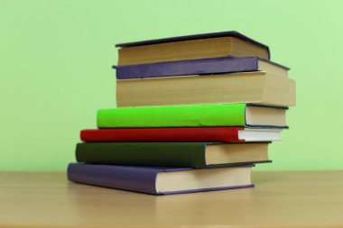 Tahta masadaki kitap yığını.