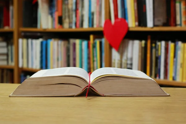 stock image Open book on the table in library