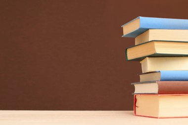 Tahta masadaki kitap yığını.