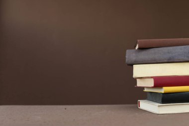 Tahta masanın üzerinde bir yığın eski kitap.
