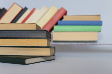 Beyaz ahşap arka planda bir yığın kitap