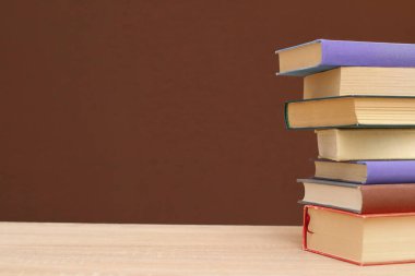 Tahta masadaki kitap yığını.