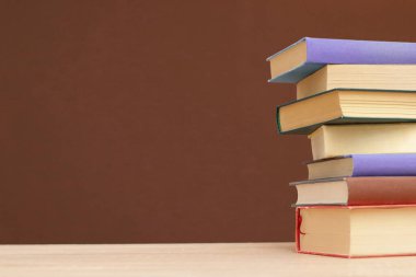 Tahta masadaki kitap yığını.