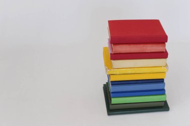 Beyaz arkaplan üzerine renkli kitap yığını