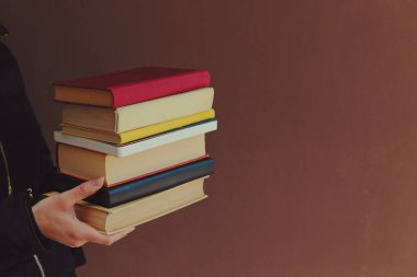 man holding a stack of books on a white background