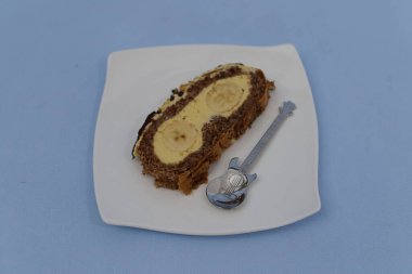 a piece of cake with a knife and a spoon on a white background
