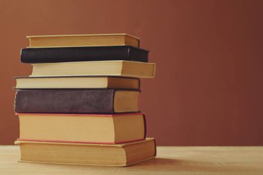 Tahta masadaki kitap yığını.