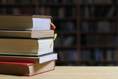 stack of hardback books on wooden table background