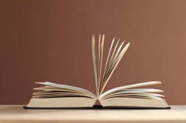 Açılmış kitap, ahşap masanın üzerindeki ciltli kitaplar.