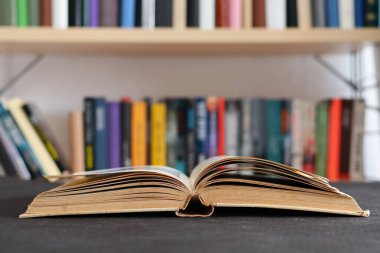Kütüphanedeki ahşap masada yığınla kitap.
