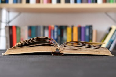 Kütüphanedeki ahşap masada yığınla kitap.