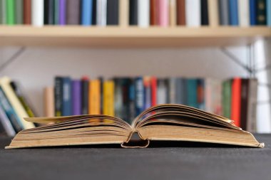 Kütüphanedeki ahşap masada yığınla kitap.