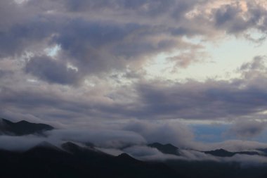 Bulutları ve mavi gökyüzü olan güzel bir manzara.