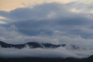 Bulutları ve mavi gökyüzü olan güzel bir manzara.
