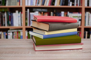 Tahta masadaki kitap yığını.