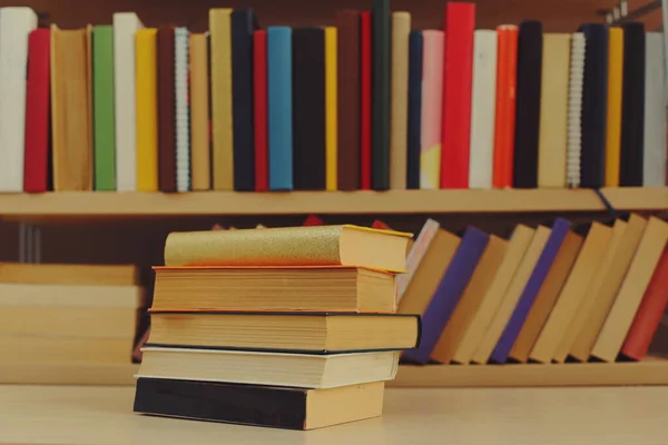 图书馆木桌上堆积如山的书 — 图库照片
