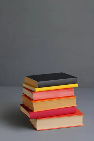 books on wooden table against grey wall. space for text