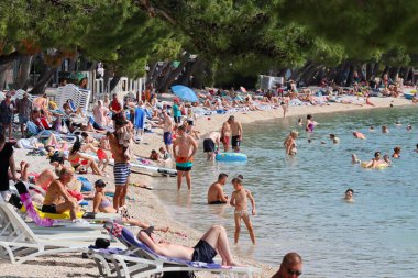 Makarska, Hırvatistan, 02.06.2023. Turistler, Hırvatistan 'da deniz kıyısındaki yıllık tatillerinin keyfini çıkarıyorlar.