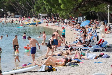 Makarska, Hırvatistan, 02.06.2023. Turistler, Hırvatistan 'da deniz kıyısındaki yıllık tatillerinin keyfini çıkarıyorlar.