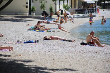 Makarska, Hırvatistan, 23,06.2023 Avrupalı turist deniz kıyısında dinleniyor