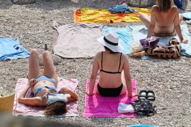 Makarska, Hırvatistan, 24 Haziran 2023. Hırvatistan 'ın güneyindeki sahildeki turistler denizin keyfini çıkarıyorlar