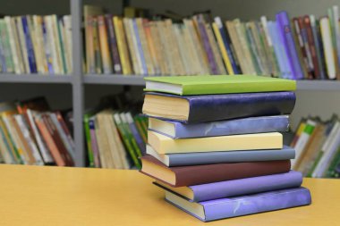 Kütüphanedeki masanın üzerinde kitap yığını