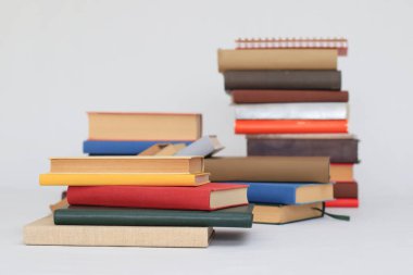 Masanın üzerinde beyaz arka planda bir yığın kitap var. Okula geri dön..