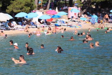 Makarska, Hırvat, 15.07.2023. Hırvatistan 'da tatil yapan turistler deniz ve güneşin keyfini çıkarıyorlar.