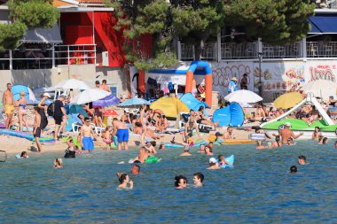 Makarska, Hırvat, 15.07.2023. Hırvatistan 'da tatil yapan turistler deniz ve güneşin keyfini çıkarıyorlar.