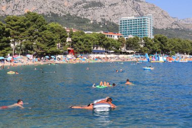 Makarska, Hırvat, 15.07.2023. Hırvatistan 'da tatil yapan turistler deniz ve güneşin keyfini çıkarıyorlar.